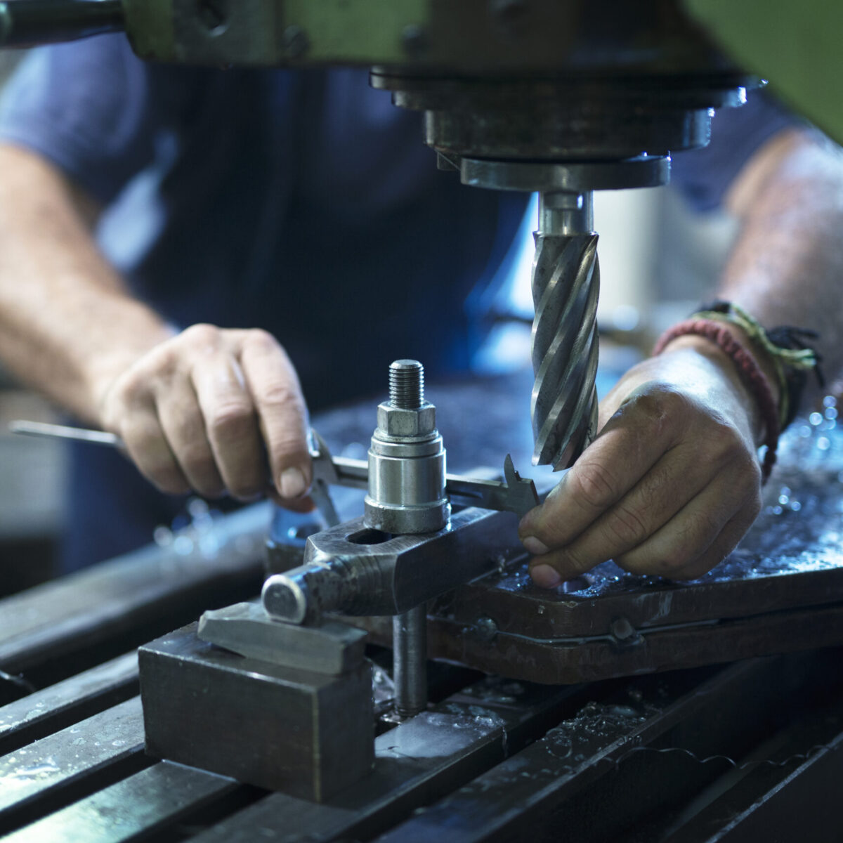 worker-operating-industrial-machine-metal-workshop-scaled.jpg